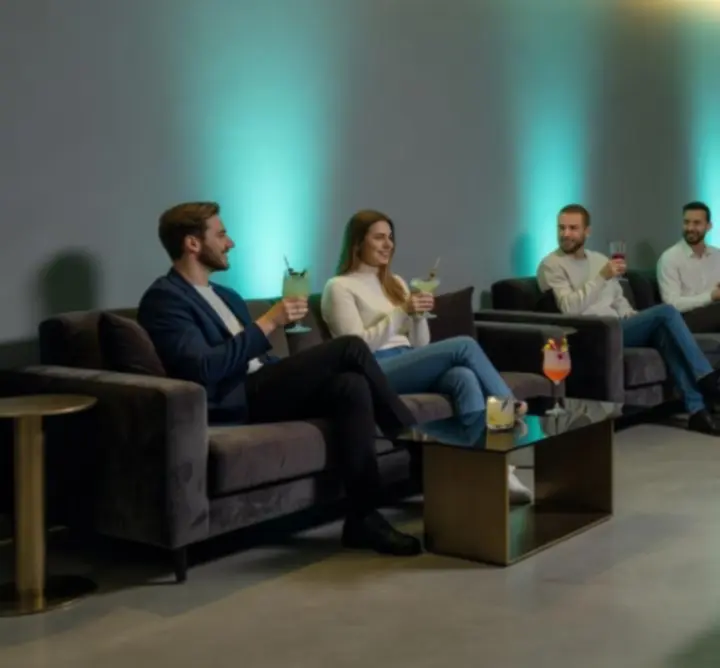 Hosté relaxující v lounge zóně s koktejly